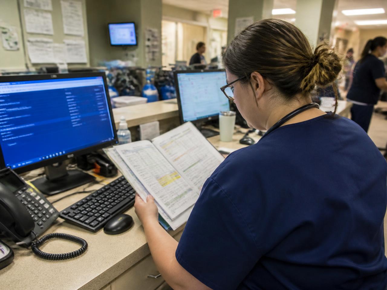 Nurses reviewing patient charts at a hospital nursing station