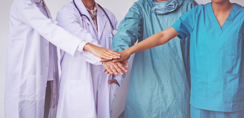 vecteezy_doctors-and-nurses-coordinate-hands-concept-teamwork_7182796-min